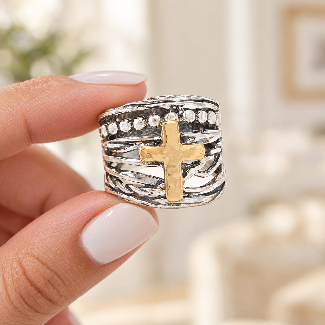 Abby Cross Ring held between fingertips