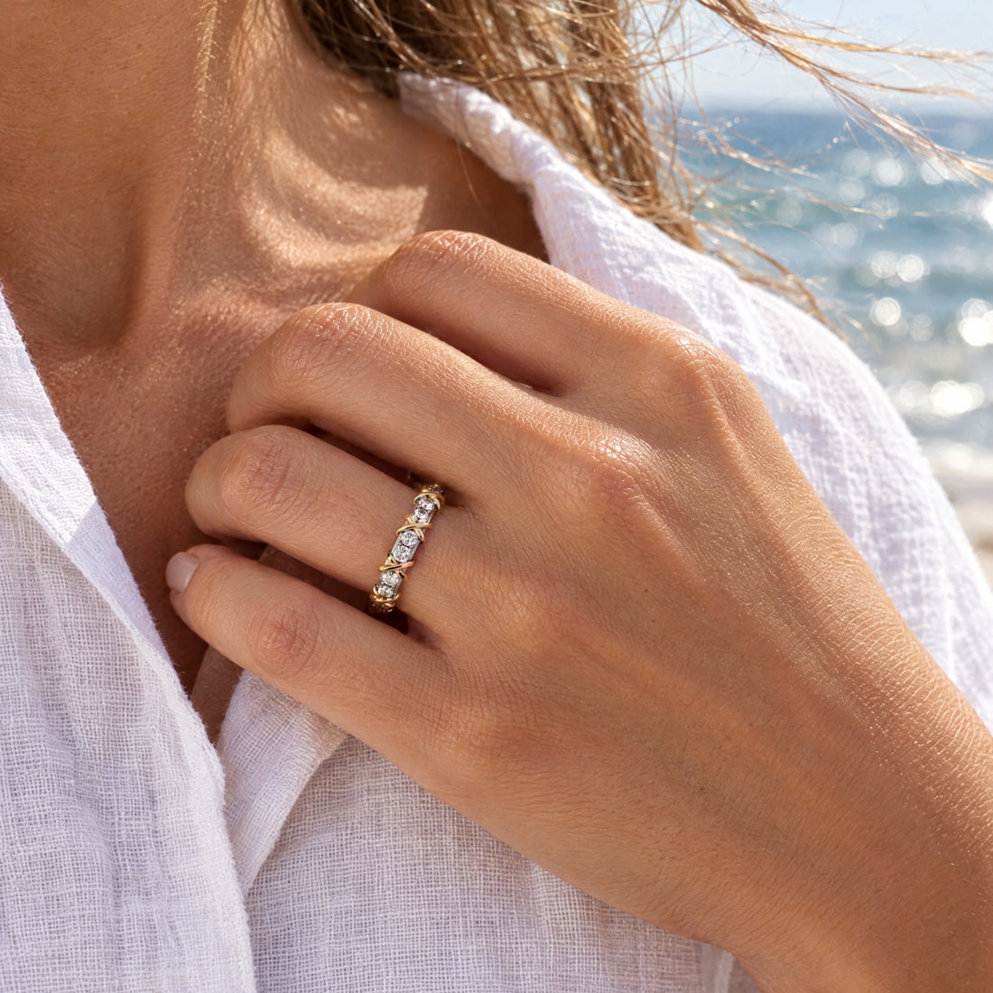 Giana Gemstone Ring worn, hand at the collar of a linen shirt by the sea