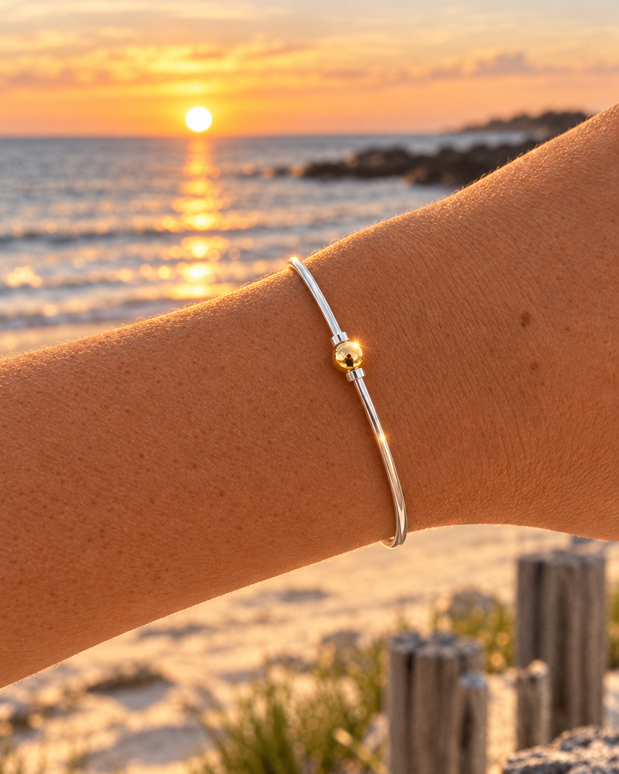 Coastal Ball Bracelet worn on a raised wrist at the beach at golden hour