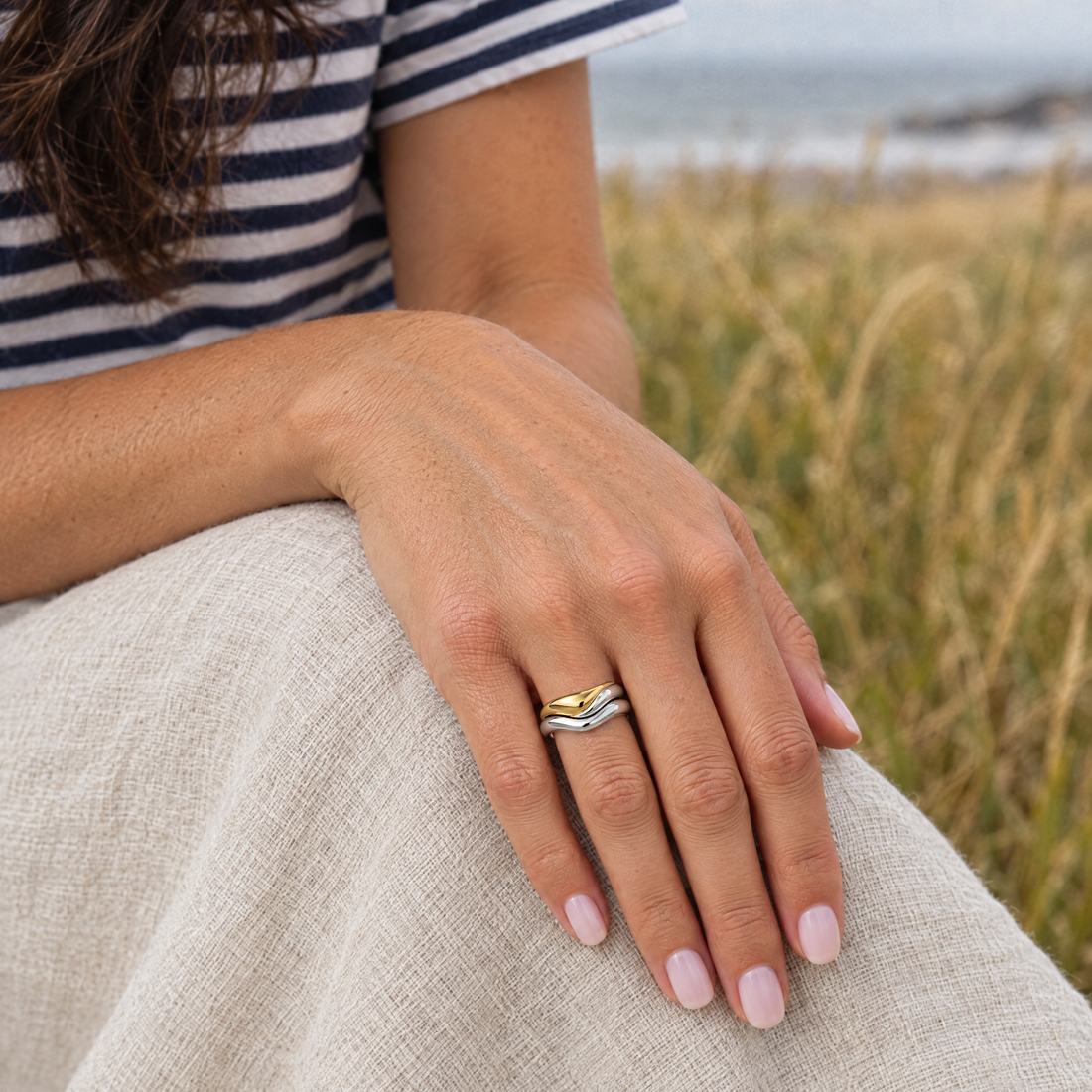 Ripple Wave Ring worn with a navy and white striped tee, a meadow of tall golden grass by the shore